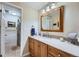 Bathroom featuring vanity with sink, a large framed mirror, updated lighting, and a shower with curtains at 7298 S Xanthia Way, Centennial, CO 80112