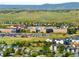 Community aerial view with a school, showcasing surrounding homes and green spaces against rolling hills at 10511 Jaguar Gln, Lone Tree, CO 80124