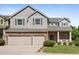 Charming two-story home featuring a brick facade, attached two-car garage, and well-manicured lawn at 10511 Jaguar Gln, Lone Tree, CO 80124