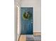 Stylish front door with decorative wreath, leading into a bright entryway with hardwood floors at 10511 Jaguar Gln, Lone Tree, CO 80124