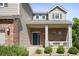 Inviting front porch with brick accents, white columns, seating, and a charming front door with wreath at 10511 Jaguar Gln, Lone Tree, CO 80124