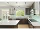 Bright kitchen with white quartz countertops and dark cabinets, bathed in natural light from the window at 10511 Jaguar Gln, Lone Tree, CO 80124