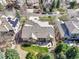Aerial view of house with landscaped yard, mature trees, and stone patio with grill at 2885 W 115Th Dr, Denver, CO 80234