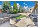 Stone back patio with fire pit, outdoor grill, mature trees, and beautiful landscaping at 2885 W 115Th Dr, Denver, CO 80234
