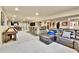 Open finished basement with a large sectional sofa, bar stools, dining table and space for entertainment at 2885 W 115Th Dr, Denver, CO 80234