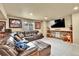 Basement living room with a sectional sofa, TV area and decorative stone accents around the TV at 2885 W 115Th Dr, Denver, CO 80234