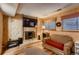 Cozy Gathering room featuring a brick fireplace and wood-paneled walls at 4582 Granby Way, Denver, CO 80239