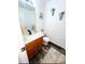 Bright bathroom with wood-look flooring, white vanity, and decorative wall hangings at 14873 E 119Th Ave, Commerce City, CO 80603