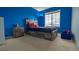 Charming bedroom features bold blue walls, a rustic wood bed frame, and ample natural light from a large window at 14873 E 119Th Ave, Commerce City, CO 80603