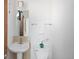 Clean and simple half bathroom with a pedestal sink, toilet, and a small window at 2900 Inca St # 7, Denver, CO 80202