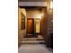 Inviting entrance with brick surround, modern lighting, glass-paneled door, and a glimpse of the interior stairs at 2900 Inca St # 7, Denver, CO 80202