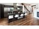 Modern kitchen with stainless steel appliances, island with seating, open staircase, hardwood floors, and cozy fireplace at 2900 Inca St # 7, Denver, CO 80202