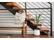 Modern staircase with wooden steps and a metal railing, complemented by a stylish bench and plant at 2900 Inca St # 7, Denver, CO 80202