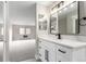 This bathroom has a modern vanity with a sleek mirror and leads into a large, empty room at 14050 E Linvale Pl # 309, Aurora, CO 80014