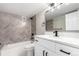Modern bathroom with neutral chevron tile accent, modern vanity and sleek fixtures, with tub and shower at 14050 E Linvale Pl # 309, Aurora, CO 80014