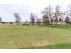 Picturesque golf course view featuring a vibrant green with a yellow flag and residential houses in the background at 14050 E Linvale Pl # 309, Aurora, CO 80014