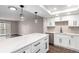Bright modern kitchen featuring white cabinets, island with pendant lighting, and hardwood flooring at 14050 E Linvale Pl # 309, Aurora, CO 80014