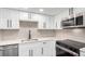 Updated kitchen with white cabinets, stainless steel appliances, and modern fixtures at 14050 E Linvale Pl # 309, Aurora, CO 80014