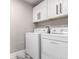 Clean laundry room with white cabinets and patterned flooring featuring a modern washer and dryer at 14050 E Linvale Pl # 309, Aurora, CO 80014