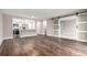 Open living area with hardwood floors and sliding barn door to carpeted bedroom at 14050 E Linvale Pl # 309, Aurora, CO 80014
