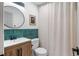 Bathroom featuring a wood vanity, round mirror, new faucet, and a shower with a white curtain at 3738 Black Feather Trl, Castle Rock, CO 80104