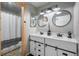 Bathroom featuring double sink vanity, round mirrors, decorative lights, and a shower with curtain at 3738 Black Feather Trl, Castle Rock, CO 80104