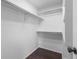 Walk-in closet with dark wood flooring, white walls, and built-in shelving for optimal storage at 3738 Black Feather Trl, Castle Rock, CO 80104