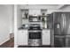 Modern kitchen with stainless steel appliances, white cabinets, and backsplash with open shelving at 3738 Black Feather Trl, Castle Rock, CO 80104