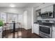 Modern kitchen area featuring stainless steel appliances, bright windows, and a cozy breakfast nook with seating at 3738 Black Feather Trl, Castle Rock, CO 80104
