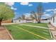 View of a charming backyard with well-maintained lawn, storage shed, and detached garage at 701 Emporia St, Aurora, CO 80010