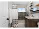 Updated bathroom with gray accent tile in the shower, a large vanity, and white towels at 701 Emporia St, Aurora, CO 80010