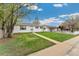 Single-story home featuring a lush green lawn, sidewalk, and mature trees under a partly cloudy sky at 701 Emporia St, Aurora, CO 80010