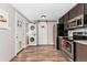 Laundry room with stacked washer and dryer and stainless appliances with wood look floors at 701 Emporia St, Aurora, CO 80010