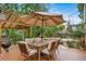 Outdoor dining on the wood deck with a large umbrella, grill, and manicured landscaping in the backyard at 17372 E Prentice Cir, Centennial, CO 80015
