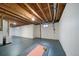 Unfinished basement with painted floors, exposed ceiling, and potential for a home gym at 17372 E Prentice Cir, Centennial, CO 80015