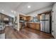 Well-equipped kitchen with stainless steel appliances and wood cabinets, adjoining a cozy living area at 17372 E Prentice Cir, Centennial, CO 80015