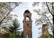 A charming bell tower framed by blossoming trees against a soft, partly cloudy blue sky at 2374 S University Blvd # 202, Denver, CO 80210
