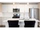 Modern kitchen with white cabinets, stainless steel appliances, and a center island with barstool seating at 2374 S University Blvd # 202, Denver, CO 80210