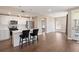 Bright kitchen with white cabinets, stainless steel appliances, island with barstool seating, and wood floors at 2374 S University Blvd # 202, Denver, CO 80210