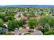 A high aerial view showcases the neighborhood's mature trees, well-maintained lawns, and varied architectural styles at 517 Chiswick Cir, Highlands Ranch, CO 80126