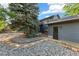 Secluded backyard featuring mature trees, gravel landscaping, and a private entrance, creating a serene outdoor space at 517 Chiswick Cir, Highlands Ranch, CO 80126