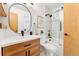 Modern bathroom features stylish wood vanity, elegant fixtures, and glass-enclosed shower over tub at 517 Chiswick Cir, Highlands Ranch, CO 80126