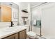 Clean bathroom features neutral toned vanity, shelves, updated fixtures, and glass-enclosed shower at 517 Chiswick Cir, Highlands Ranch, CO 80126