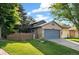 Charming two-story home boasts a brick facade, blue garage door, and well-manicured lawn, creating a welcoming curb appeal at 517 Chiswick Cir, Highlands Ranch, CO 80126