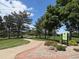 Beautifully landscaped Kistler Park with walking path and signage among lush greenery and mature trees at 517 Chiswick Cir, Highlands Ranch, CO 80126