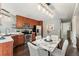 Well-lit kitchen with dining area, stainless steel appliances, wood cabinets, and dark wood floors at 517 Chiswick Cir, Highlands Ranch, CO 80126