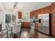 Eat-in kitchen with wood cabinets, stainless steel appliances, dark wood floors, and ample counter space at 517 Chiswick Cir, Highlands Ranch, CO 80126