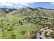 Aerial view of property showcasing solar panels, vast green space, and mountain views, perfect for outdoor enthusiasts at 225 Berthoud Way, Golden, CO 80401