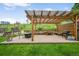 Backyard patio featuring a wooden pergola, outdoor seating, and a grill for entertaining in a green space at 225 Berthoud Way, Golden, CO 80401