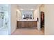 Bathroom featuring double sinks, wood cabinetry, a large mirror, and a separate shower at 225 Berthoud Way, Golden, CO 80401